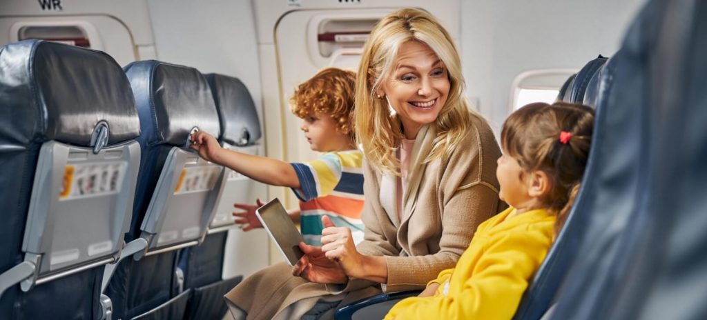 Een moeder zit met haar twee kinderen in een vliegtuig