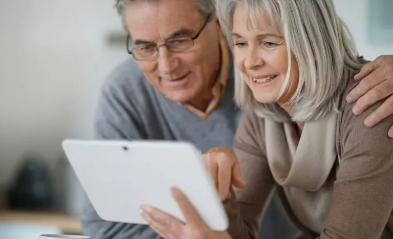 Een echtpaar van middelbare leeftijd leest tekst op een tablet
